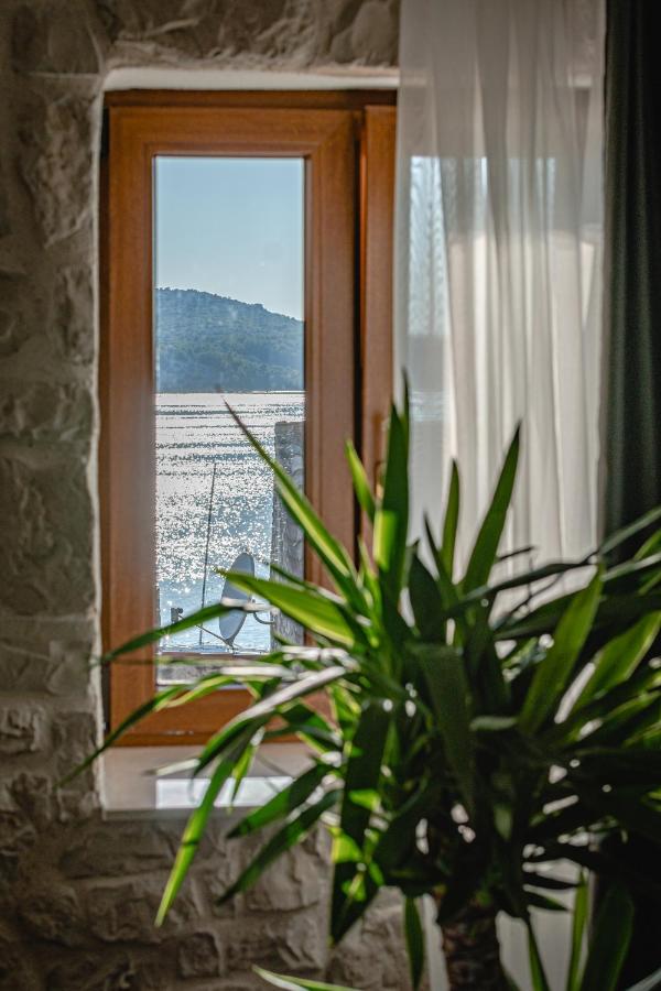 Pogled kroz prozor na more i krovove